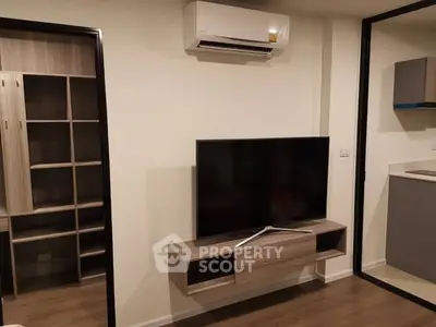 Modern living room with wall-mounted TV and air conditioning in stylish apartment.