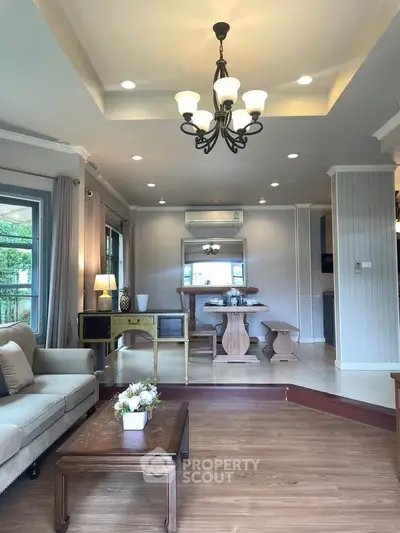 Spacious living room with elegant chandelier and cozy seating area