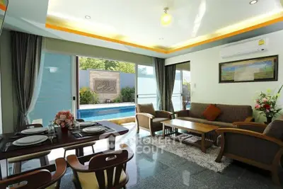 Luxurious living room with pool view, elegant dining area, and modern furnishings.