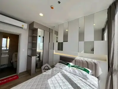 Modern bedroom with mirrored wall and stylish decor in a high-rise apartment.