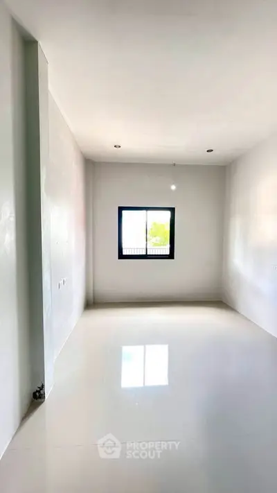 Spacious empty room with large window and glossy white flooring, perfect for customization.