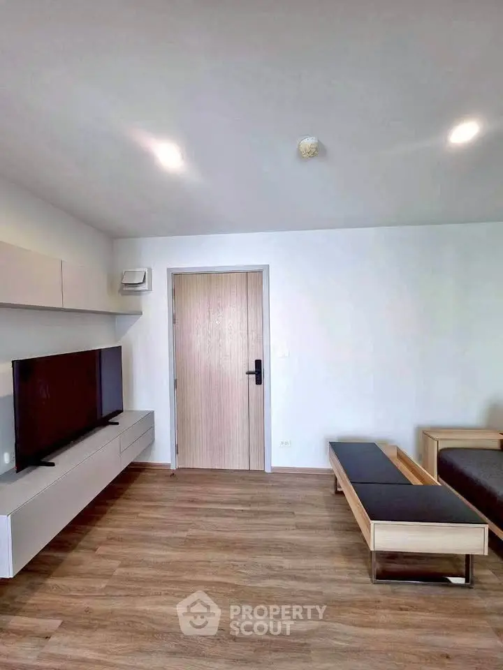 Modern living room with sleek TV setup and wooden flooring, perfect for contemporary living.