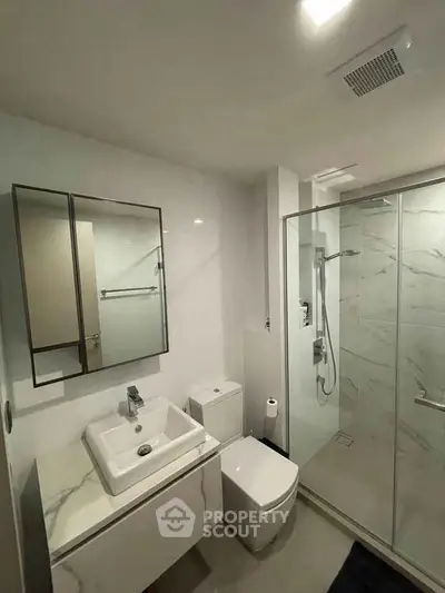 Modern bathroom with sleek design, featuring a glass shower and stylish vanity.