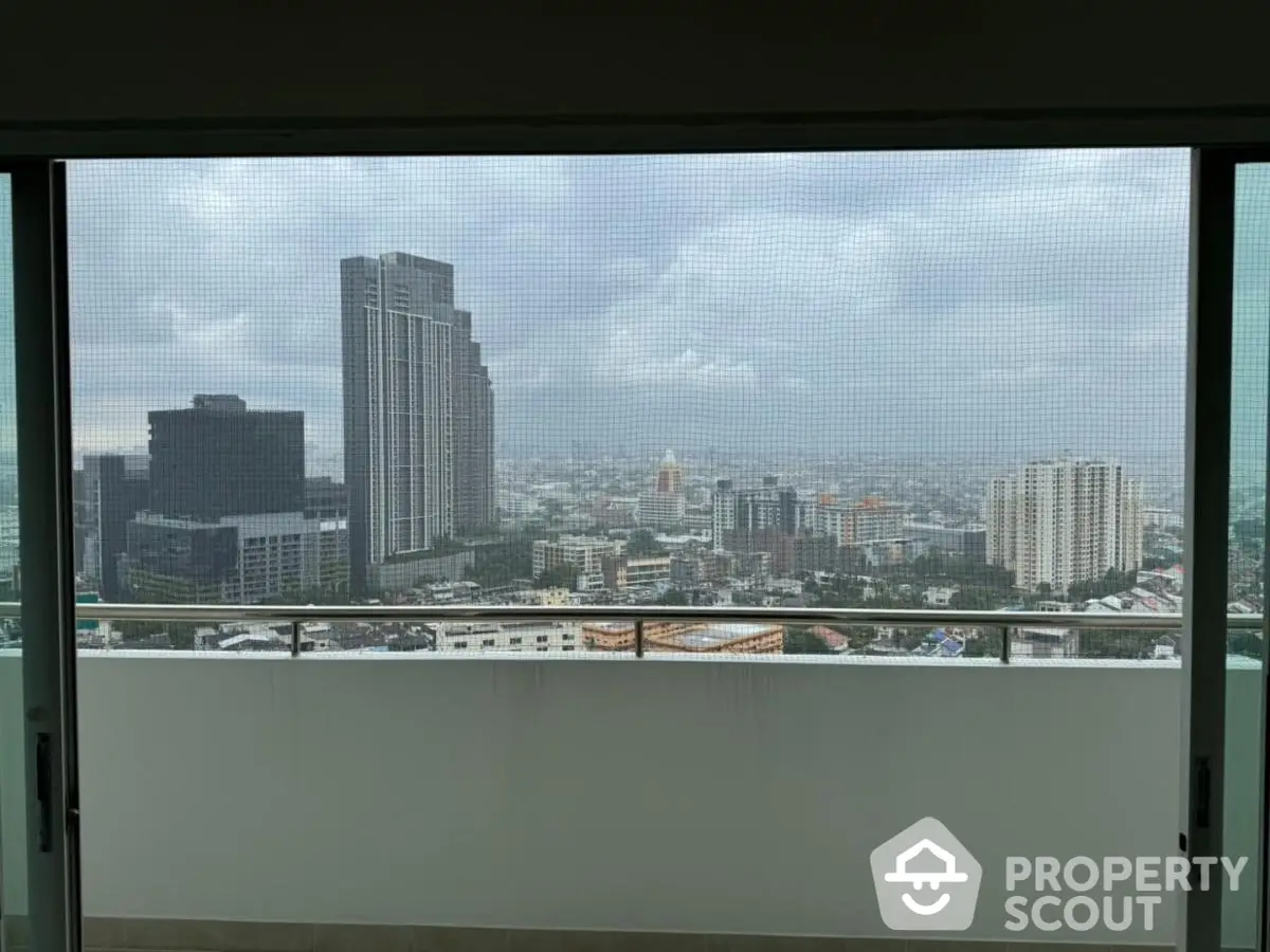 Stunning cityscape view from high-rise balcony with modern railing.