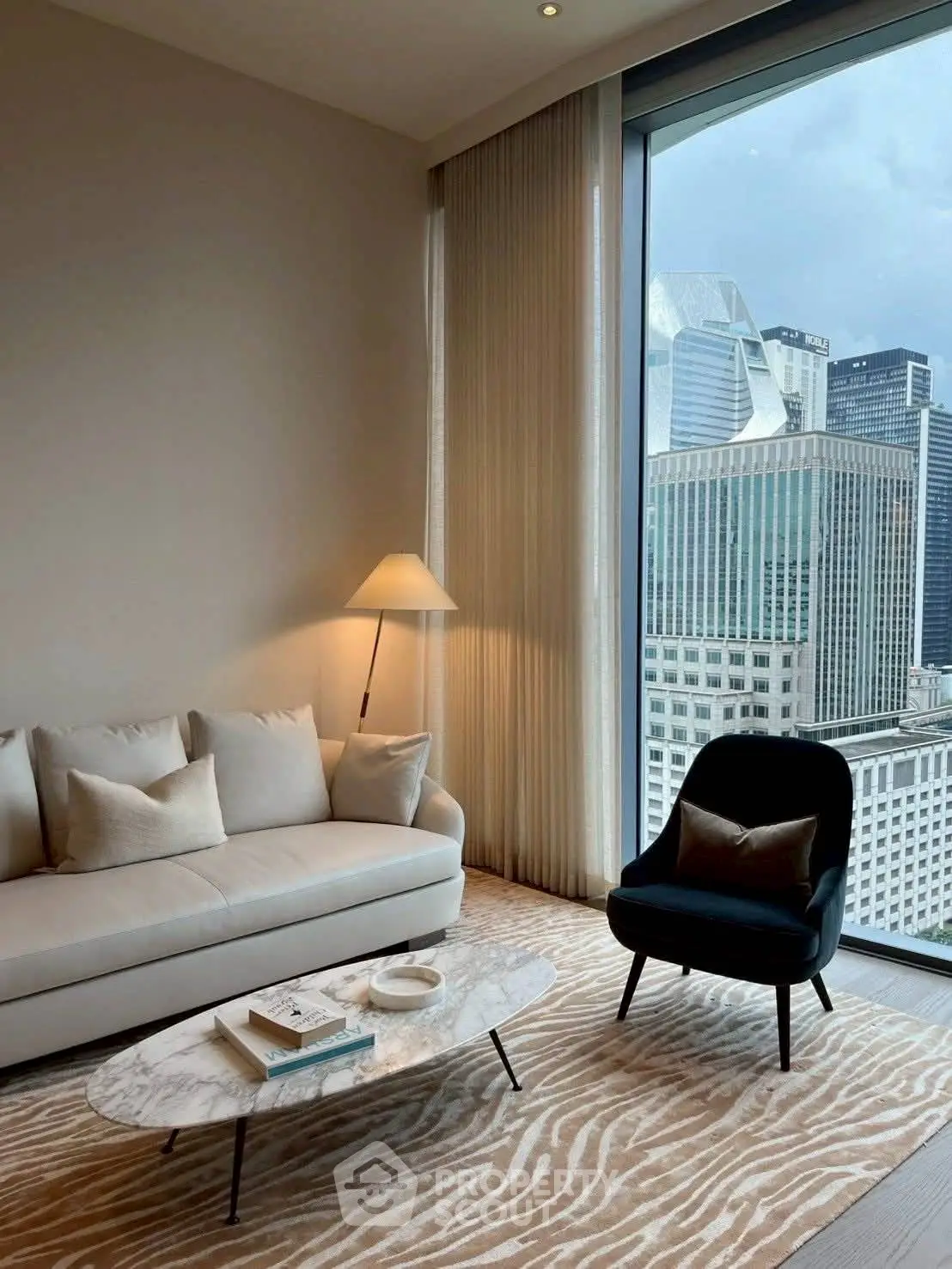 Luxurious living room with stunning city view, elegant furniture, and floor-to-ceiling windows.