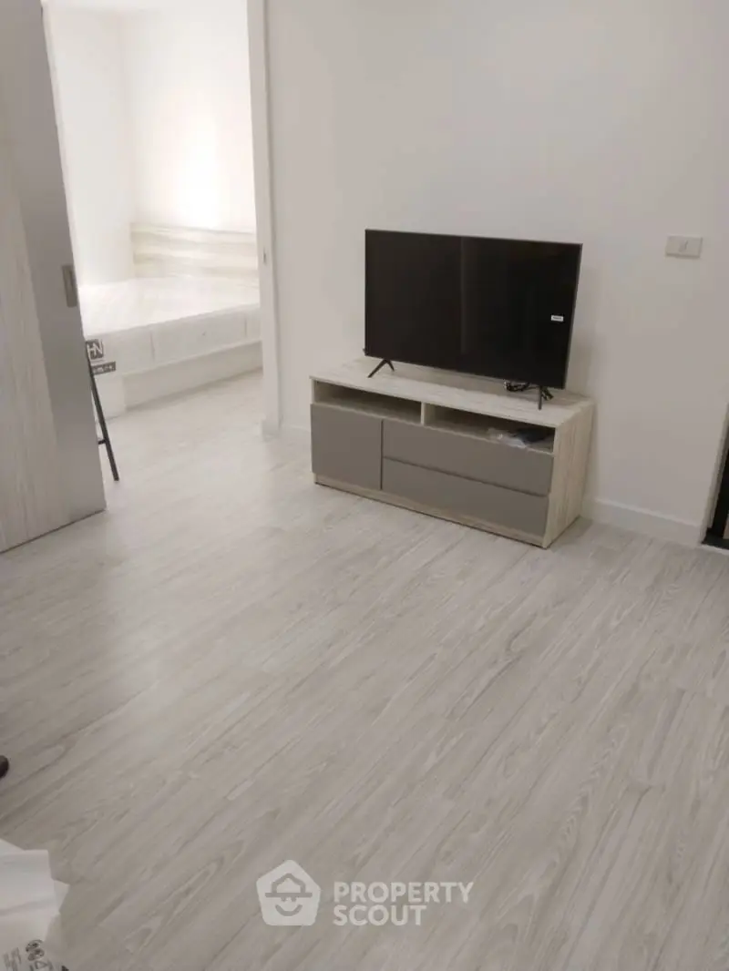 Modern living room with sleek TV stand and bedroom view