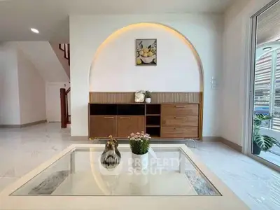 Modern living room with stylish furniture and elegant decor, featuring a unique arch design and glass coffee table.