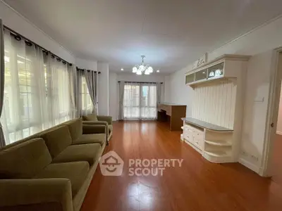 Spacious living room with elegant wooden flooring and ample natural light.