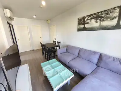 Modern living room with cozy sofa and dining area in stylish apartment.