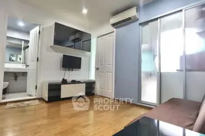 Modern living room with sleek design, featuring hardwood floors, wall-mounted TV, and air conditioning.