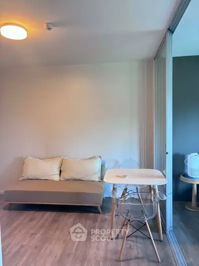 Modern living room with cozy sofa and stylish dining area in open layout apartment.