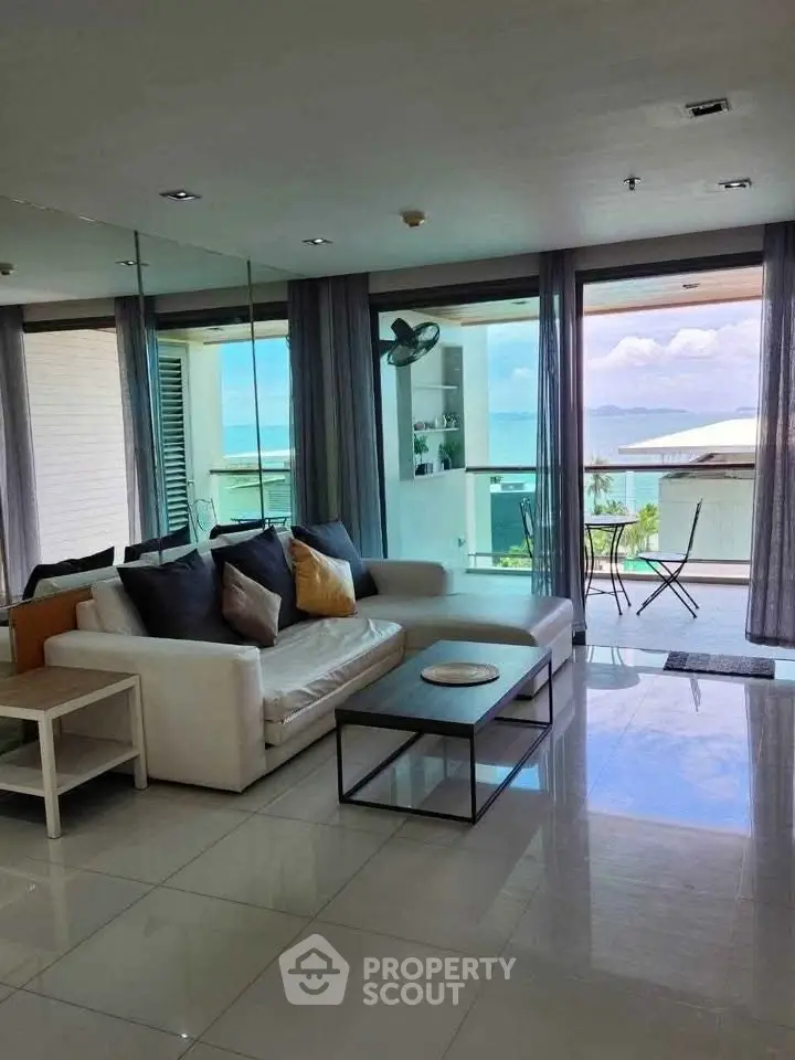 Luxurious living room with ocean view and spacious balcony in modern apartment.