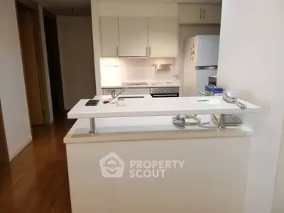 Modern kitchen with sleek white cabinets and appliances