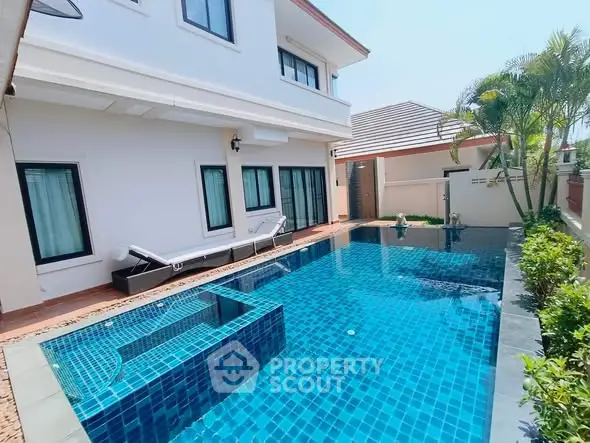 Luxurious villa with private swimming pool and sun loungers, perfect for relaxation.