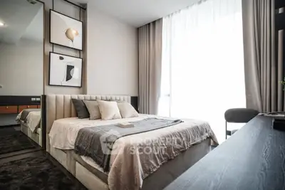 Modern bedroom with stylish decor and large window offering natural light