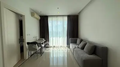 Modern living room with sleek sofa and large window offering natural light.