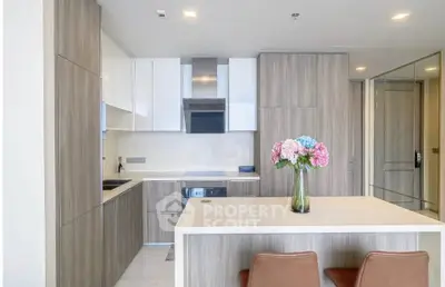 Modern kitchen with sleek cabinetry and island, featuring a stylish open layout and contemporary design.