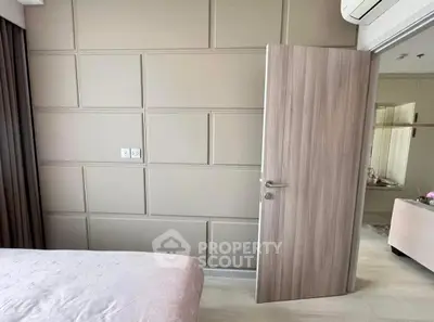 Modern bedroom with stylish panel wall and wooden door
