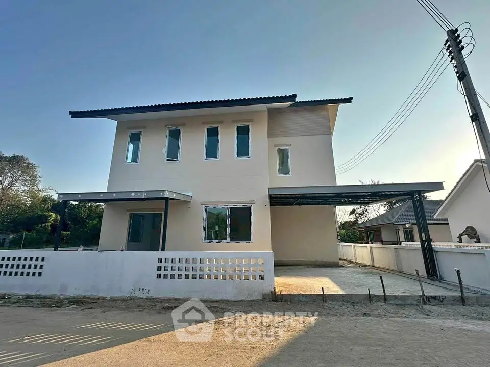 Modern two-story house with minimalist design and spacious driveway in a serene neighborhood.