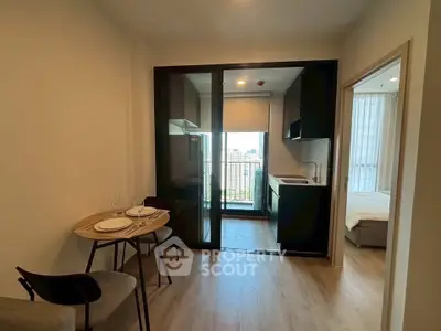 Modern apartment with open kitchen and dining area, featuring a city view from the balcony.