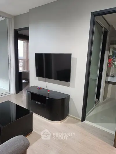 Modern living room with sleek TV setup and balcony view