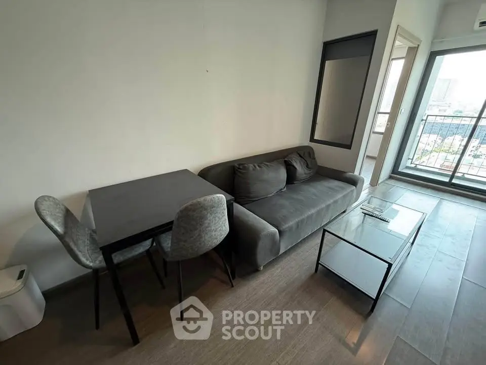 Modern living room with sleek furniture and city view balcony, perfect for urban living.