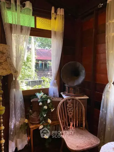 Charming vintage-style corner with gramophone and wooden chair, perfect for cozy living room ambiance.