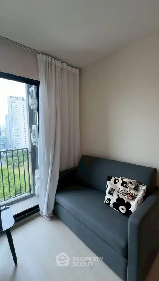 Cozy living room with modern sofa and city view balcony, perfect for urban living.