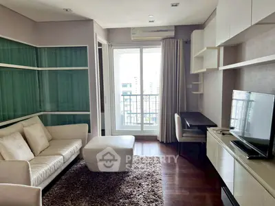 Modern living room with balcony view, featuring sleek furniture and natural light.