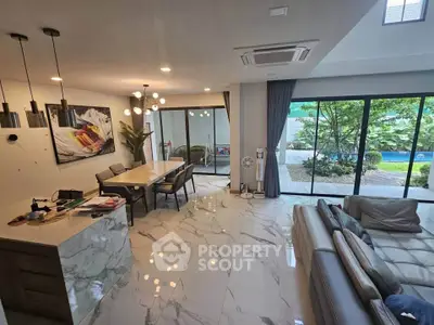 Luxurious open-plan living room with pool view and elegant marble flooring