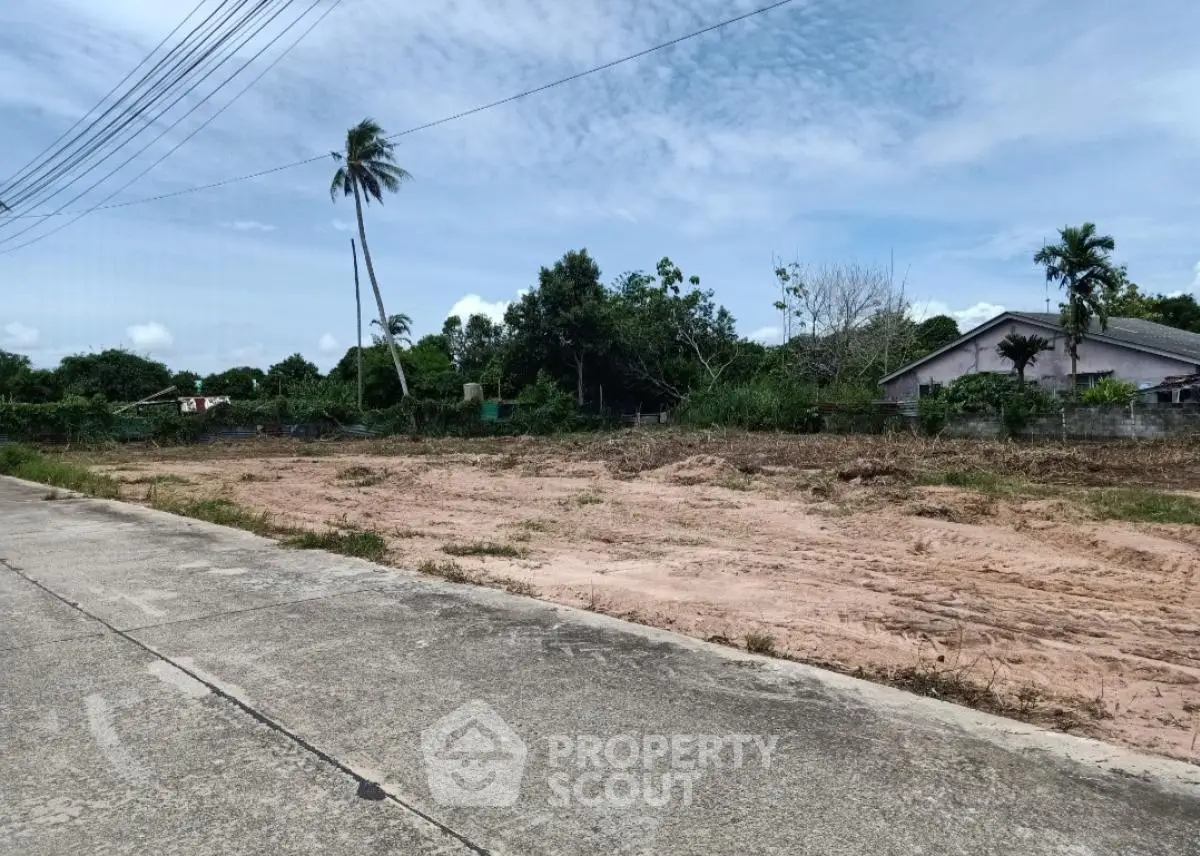 Spacious land plot with lush greenery, ideal for development in a serene neighborhood.