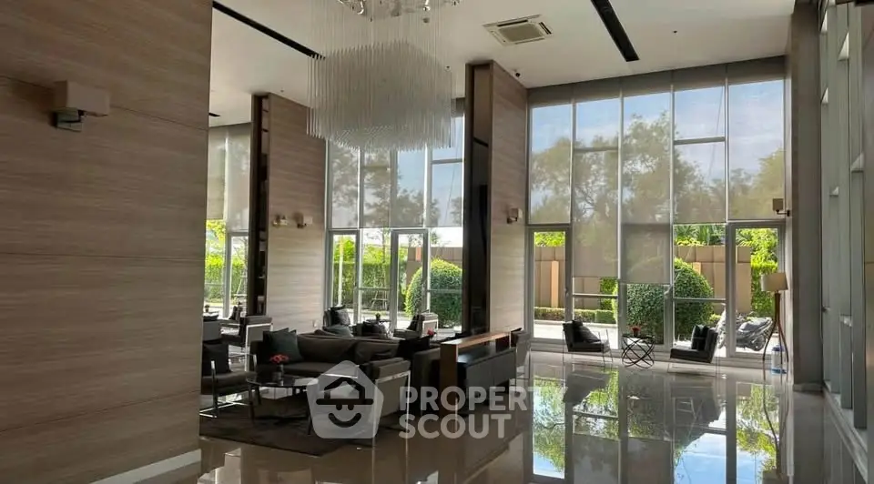 Luxurious modern lobby with high ceilings and elegant furnishings, offering a serene garden view.