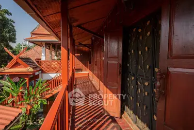 Charming traditional wooden balcony with intricate design and lush greenery