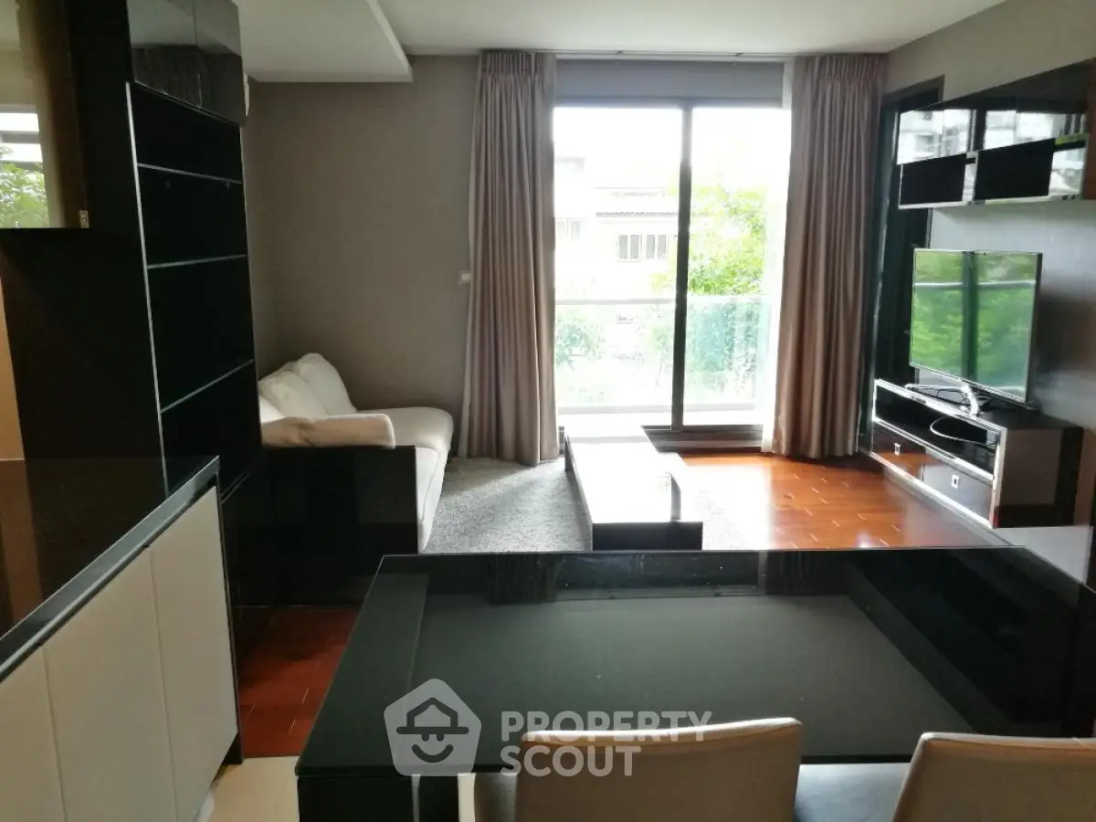 Modern living room with large window and stylish furniture, perfect for relaxation and entertainment.