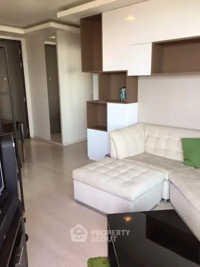 Modern living room with stylish white sectional sofa and unique shelving unit