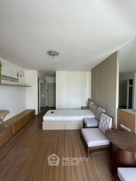 Spacious modern bedroom with wooden flooring and stylish furniture