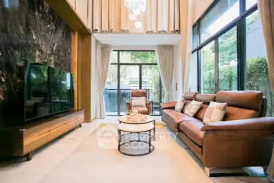 Luxurious living room with high ceilings, elegant leather furniture, and large windows offering garden views.