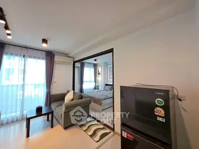 Modern apartment interior with cozy living room and stylish bedroom, featuring sleek furniture and natural light.