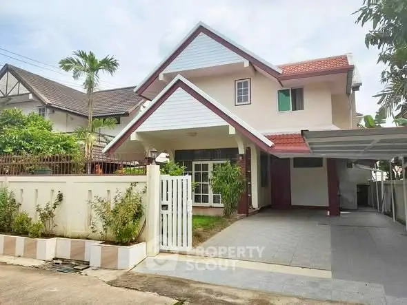 Charming two-story house with red roof and spacious driveway in a serene neighborhood.