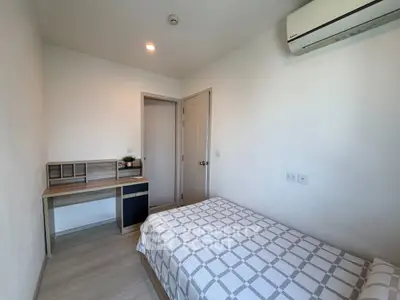 Cozy bedroom with modern desk and air conditioning in a minimalist apartment.