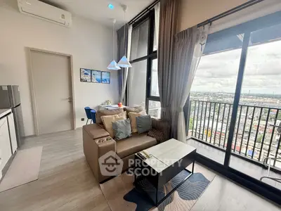 Modern living room with large windows and city view, featuring stylish decor and cozy seating area.