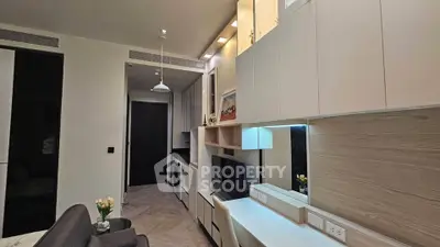 Modern living room with sleek cabinetry and elegant lighting in a contemporary apartment.