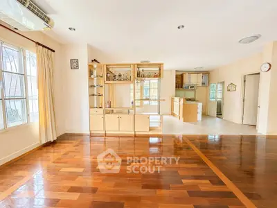 Spacious open-plan living room with wooden flooring and natural light