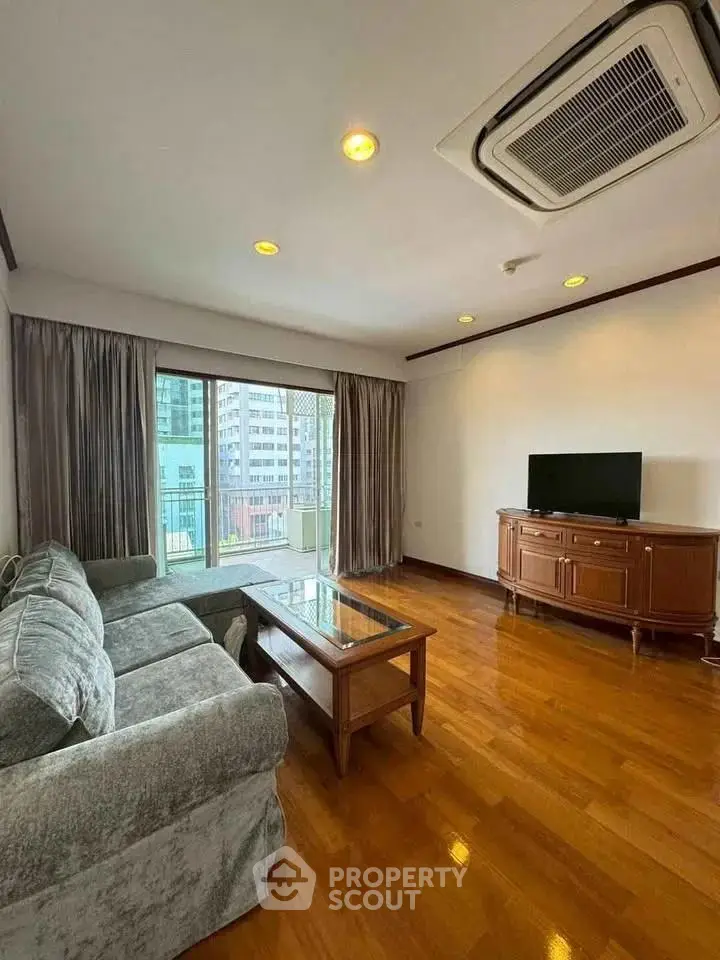 Spacious living room with elegant furniture and city view balcony in modern apartment.