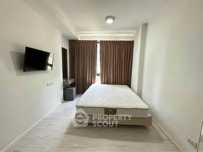 Modern bedroom with minimalist design, featuring a wall-mounted TV and large window with curtains.
