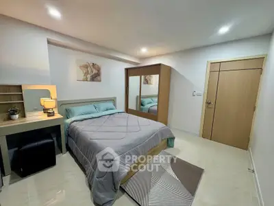 Modern bedroom with stylish decor and ample storage space, featuring a cozy bed and elegant lighting.