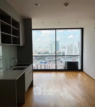 Modern apartment with open kitchen and stunning city view through large windows.