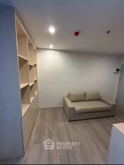 Modern living room with sleek wooden flooring and built-in shelving unit.