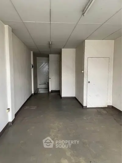 Spacious empty room with tiled floor and white walls, ideal for customization.