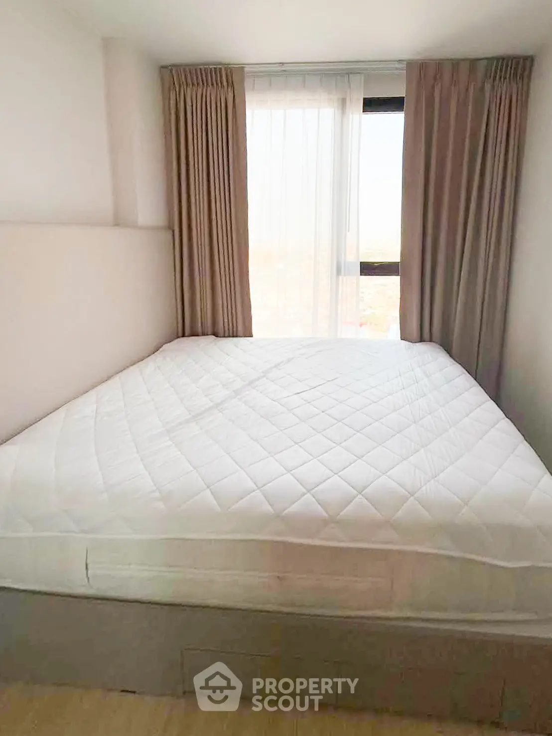 Cozy bedroom with large window and elegant curtains, perfect for relaxation and comfort.